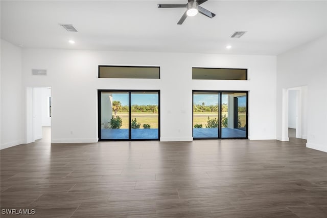 spare room featuring ceiling fan, dark hardwood / wood-style floors, and a high ceiling