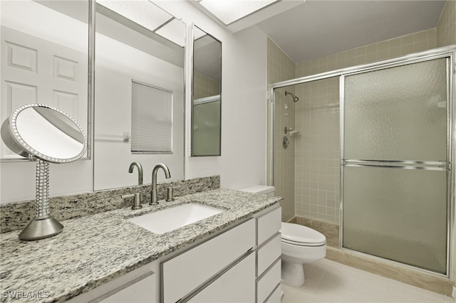 bathroom featuring toilet, tile patterned floors, walk in shower, and vanity