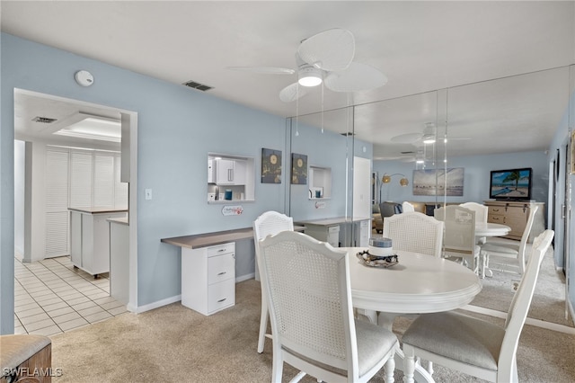 dining space with light colored carpet and ceiling fan