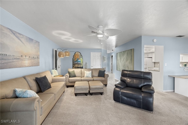 carpeted living room with ceiling fan and a textured ceiling