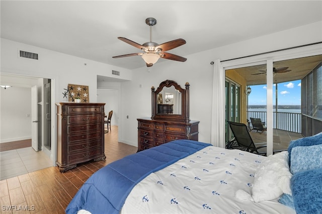 bedroom featuring a water view, ceiling fan, dark wood-type flooring, and access to exterior