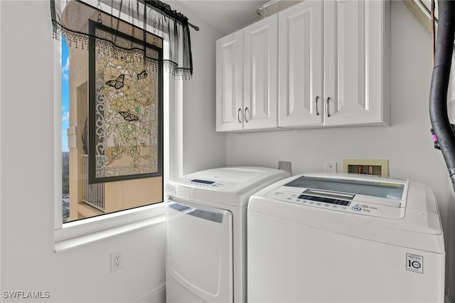 laundry room with cabinets, plenty of natural light, and washing machine and clothes dryer