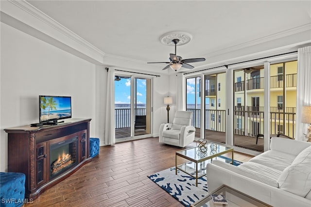 living room with ceiling fan, wood-type flooring, and ornamental molding