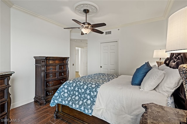 bedroom with dark wood-type flooring, crown molding, and ceiling fan