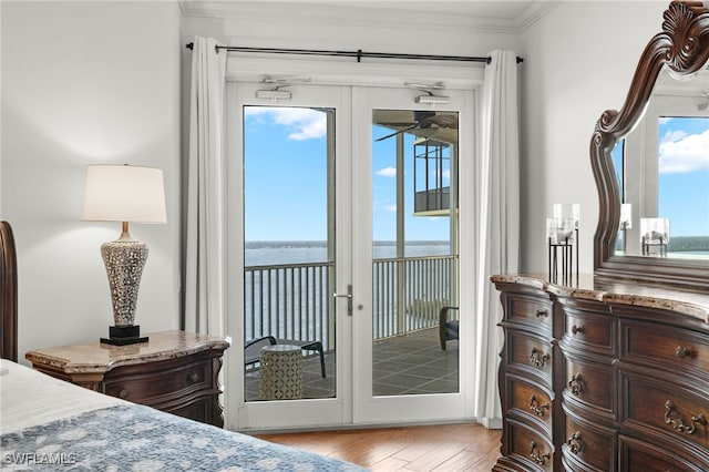 bedroom featuring a water view, access to outside, and multiple windows