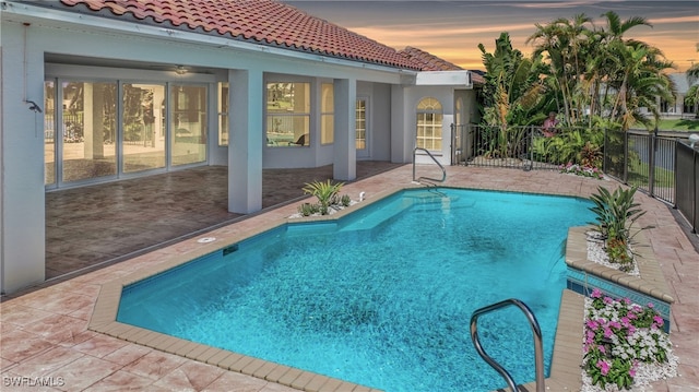 pool at dusk featuring a patio