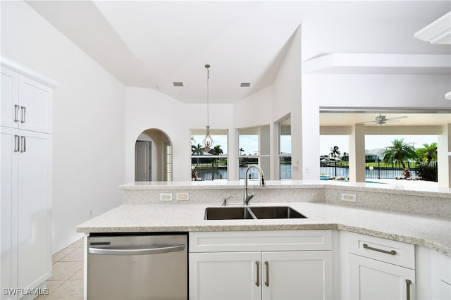 kitchen featuring a water view, white cabinets, sink, stainless steel dishwasher, and light tile patterned flooring