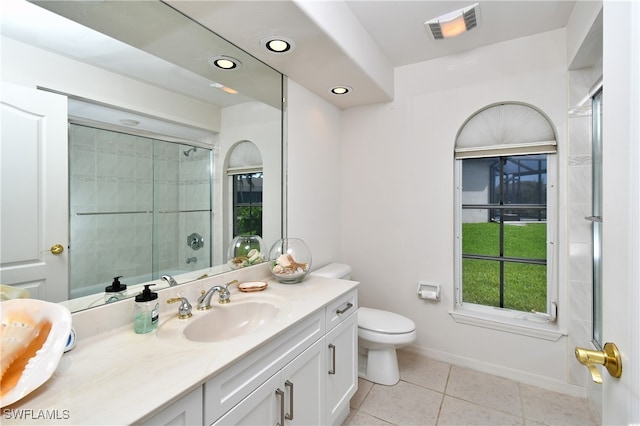 bathroom with tile patterned floors, vanity, toilet, and a shower with shower door