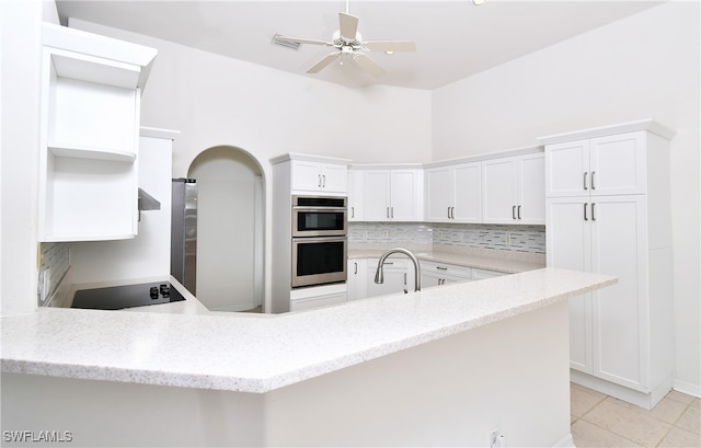 kitchen featuring stainless steel double oven, white cabinetry, kitchen peninsula, and light tile patterned floors