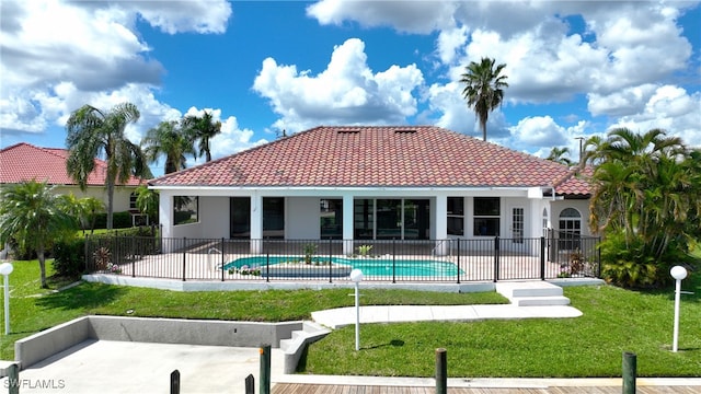 rear view of house featuring a fenced in pool, a patio area, and a yard