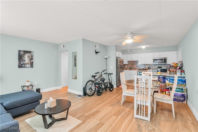 living room featuring light hardwood / wood-style floors, sink, and ceiling fan