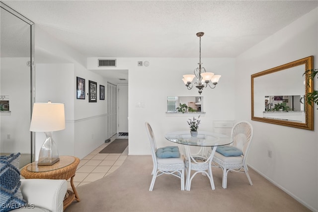 dining room featuring a notable chandelier, a textured ceiling, and light colored carpet