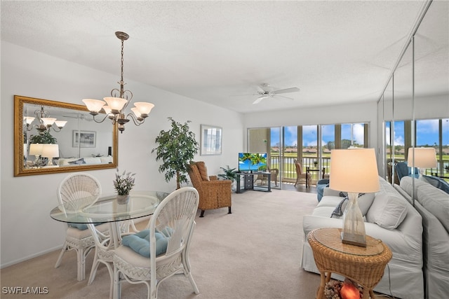 carpeted dining room featuring a textured ceiling, plenty of natural light, and ceiling fan with notable chandelier