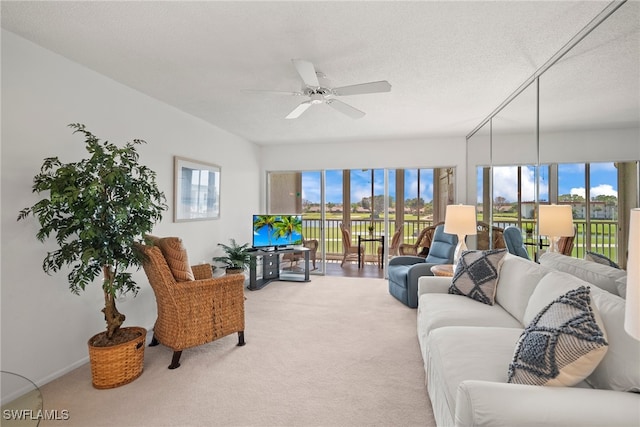 carpeted living room featuring a textured ceiling, ceiling fan, and a wealth of natural light