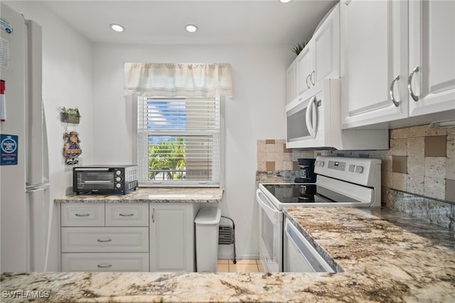 kitchen featuring white cabinetry, light tile patterned flooring, backsplash, and white appliances