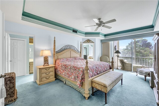 bedroom featuring a tray ceiling, ensuite bath, carpet, crown molding, and ceiling fan