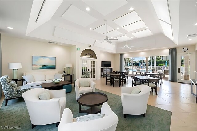 living room featuring french doors, ceiling fan, tile patterned flooring, and a raised ceiling