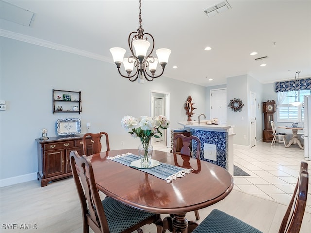 tiled dining space featuring a chandelier, sink, and ornamental molding