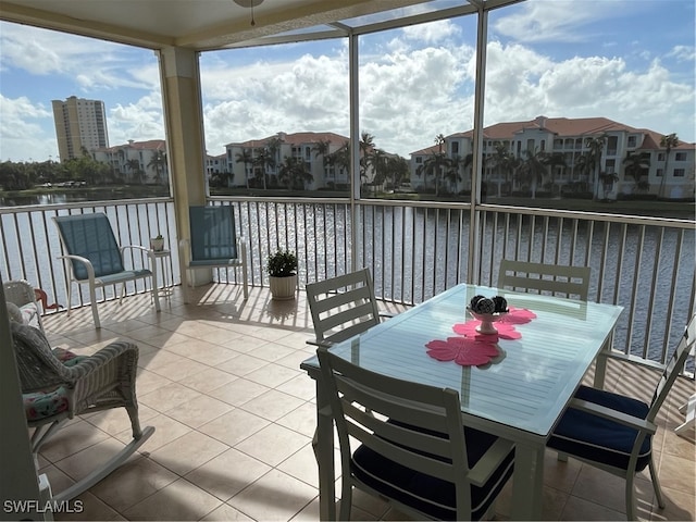 sunroom featuring a water view and ceiling fan