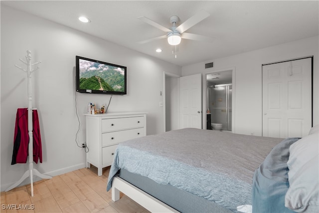 bedroom with light wood-type flooring, ceiling fan, and ensuite bathroom