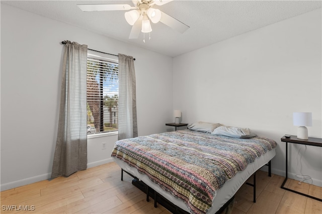 bedroom featuring ceiling fan, a textured ceiling, and light hardwood / wood-style flooring