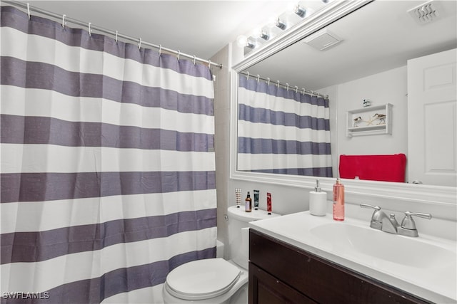 bathroom featuring toilet, vanity, and walk in shower