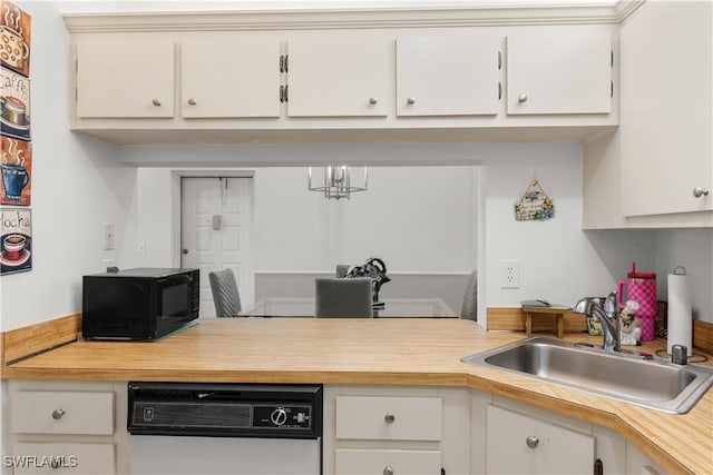 kitchen featuring an inviting chandelier, white cabinetry, sink, and dishwashing machine