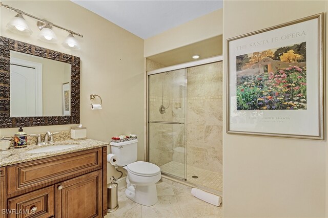 bathroom with tile patterned floors, vanity, toilet, and a shower with door