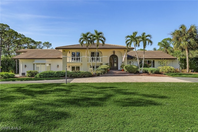 view of front of property with a balcony and a front yard