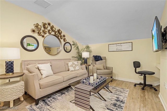 living room with light wood-type flooring and vaulted ceiling