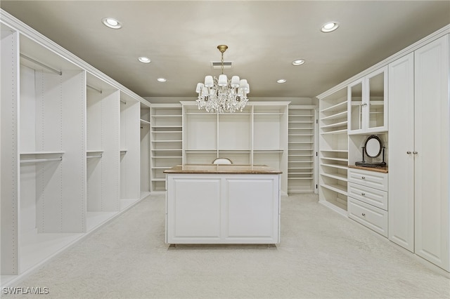 spacious closet with light carpet and a notable chandelier