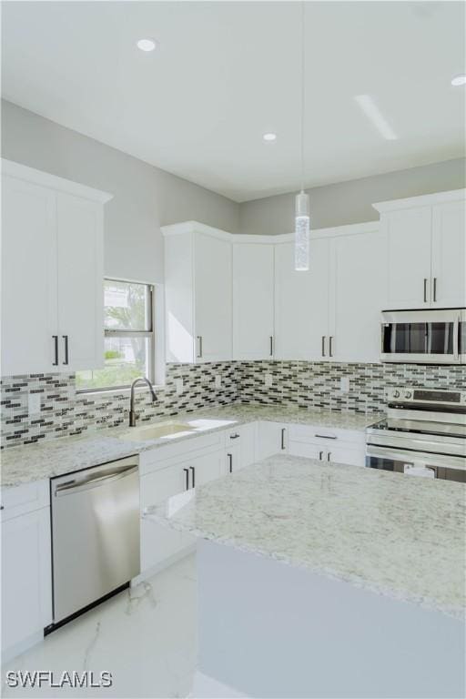 kitchen with white cabinets, stainless steel appliances, and hanging light fixtures