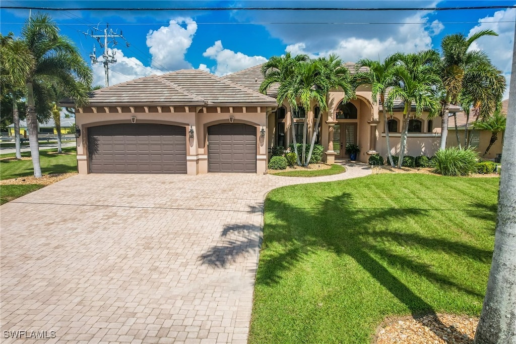 mediterranean / spanish-style house featuring a front lawn and a garage