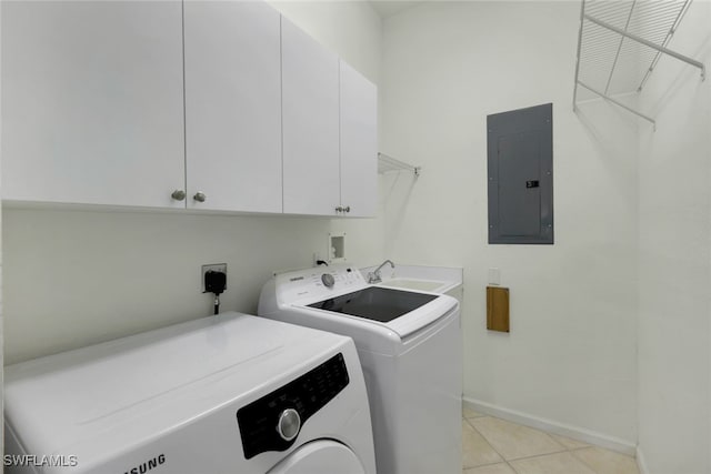 clothes washing area featuring electric panel, cabinets, washing machine and dryer, and light tile patterned floors