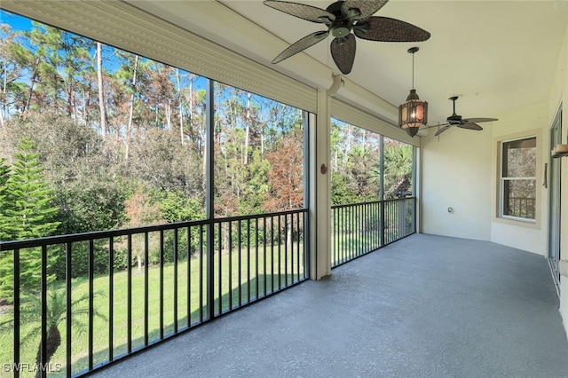 unfurnished sunroom featuring ceiling fan