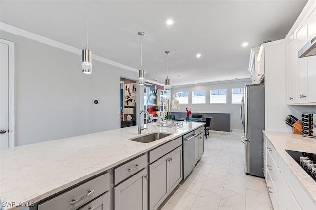 kitchen featuring stainless steel appliances, light stone counters, sink, crown molding, and pendant lighting