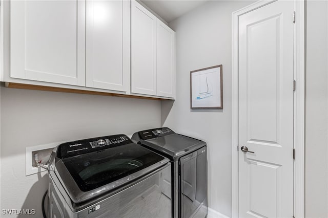 washroom with cabinets and washer and dryer