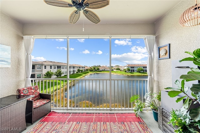 unfurnished sunroom featuring a water view, ceiling fan, and plenty of natural light