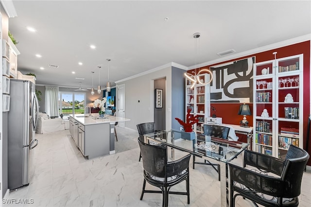 dining area featuring sink and crown molding