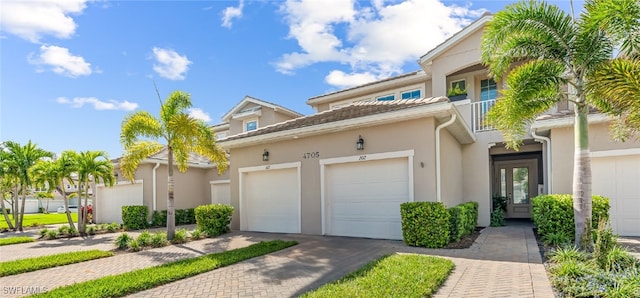 4705 Arboretum Cir Unit 202, Naples, FL 34112 - townhome / multi-family property with stucco siding, decorative driveway, an attached garage, french doors, and a balcony