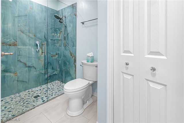 bathroom featuring a shower with shower door, tile patterned floors, and toilet