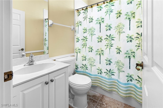 bathroom with toilet, vanity, and tile patterned flooring