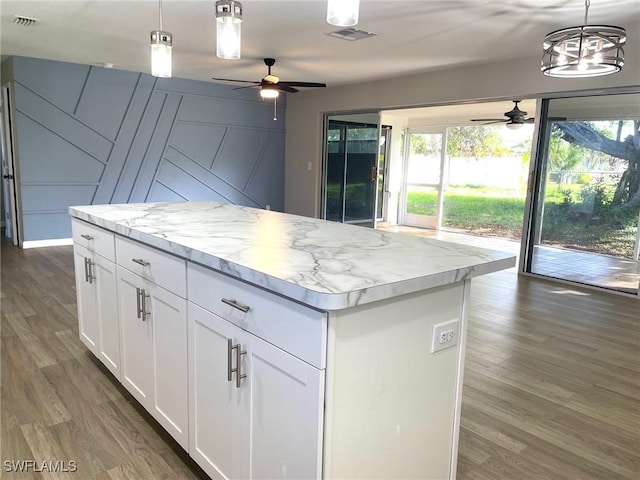 kitchen featuring white cabinetry, ceiling fan, dark hardwood / wood-style flooring, hanging light fixtures, and a kitchen island