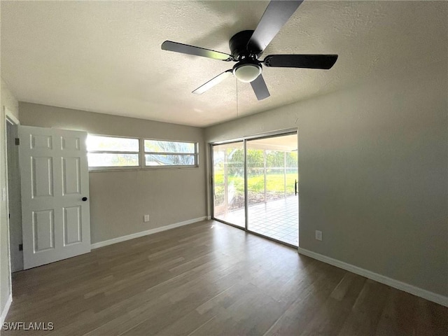 empty room with ceiling fan, a textured ceiling, and dark hardwood / wood-style flooring