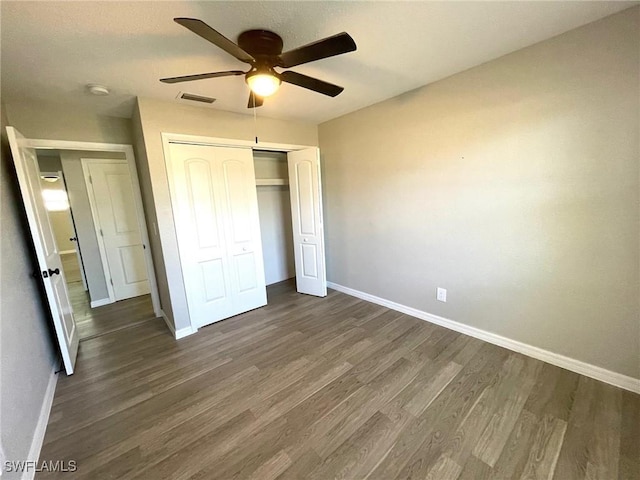 unfurnished bedroom featuring ceiling fan, dark wood-type flooring, and a closet