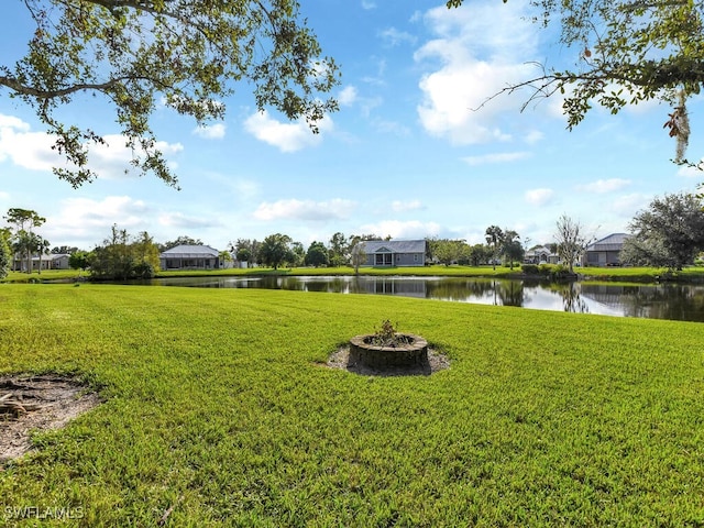 view of yard featuring a water view and an outdoor fire pit