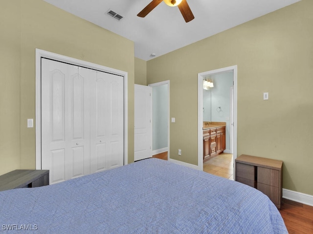 bedroom with wood-type flooring, a closet, ensuite bath, and ceiling fan