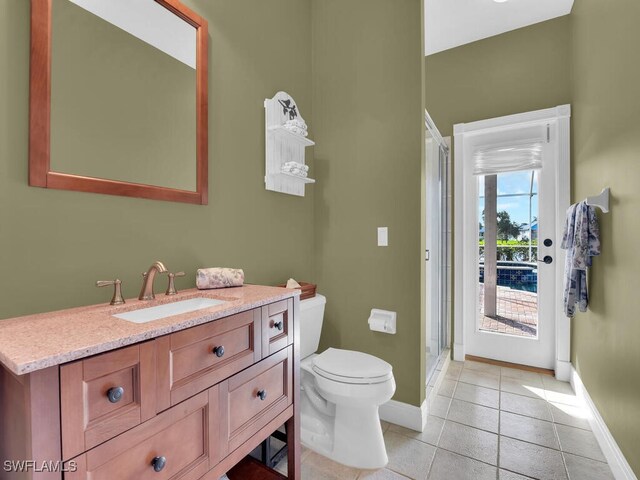 bathroom featuring tile patterned floors, vanity, toilet, and an enclosed shower