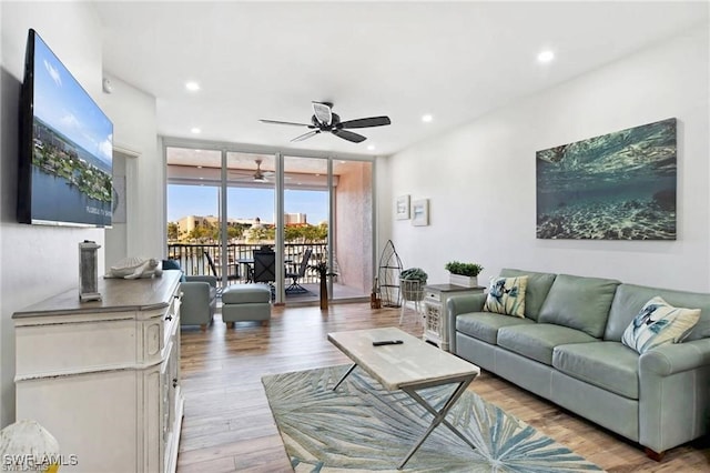 living room with expansive windows, light hardwood / wood-style flooring, and ceiling fan