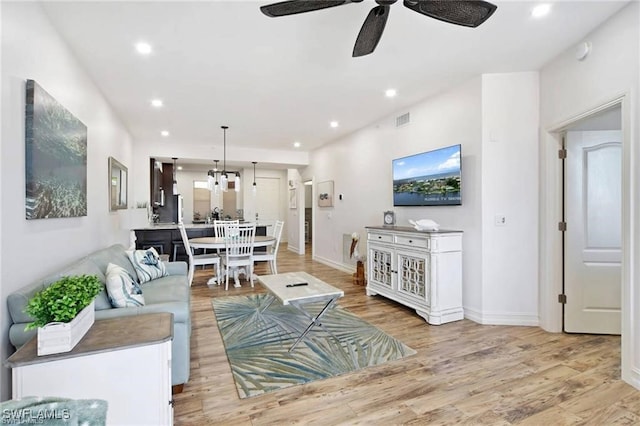 living room with light hardwood / wood-style floors and ceiling fan